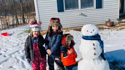Photo of Rhiannon Rose's children building a snowman outside